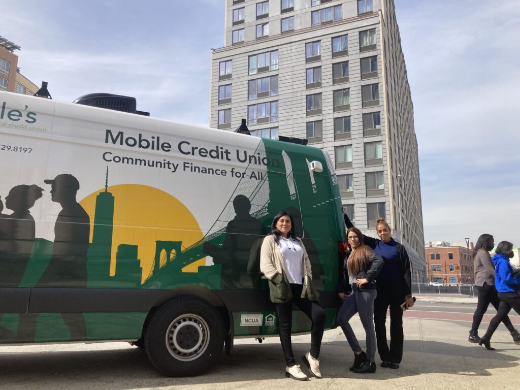 People standing in front of a van that says "Mobile Credit Union"